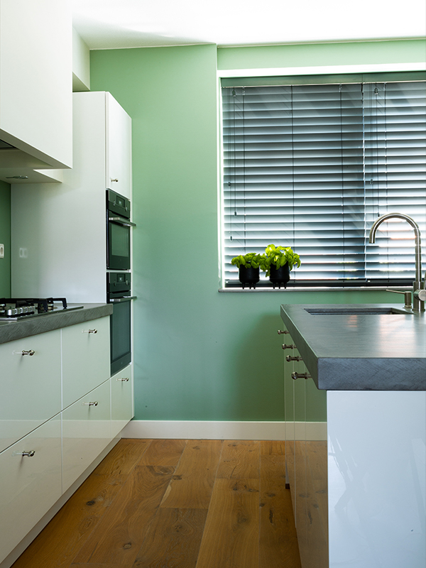 Keuken wit, groene muur, zwarte horizontale jaloezieen